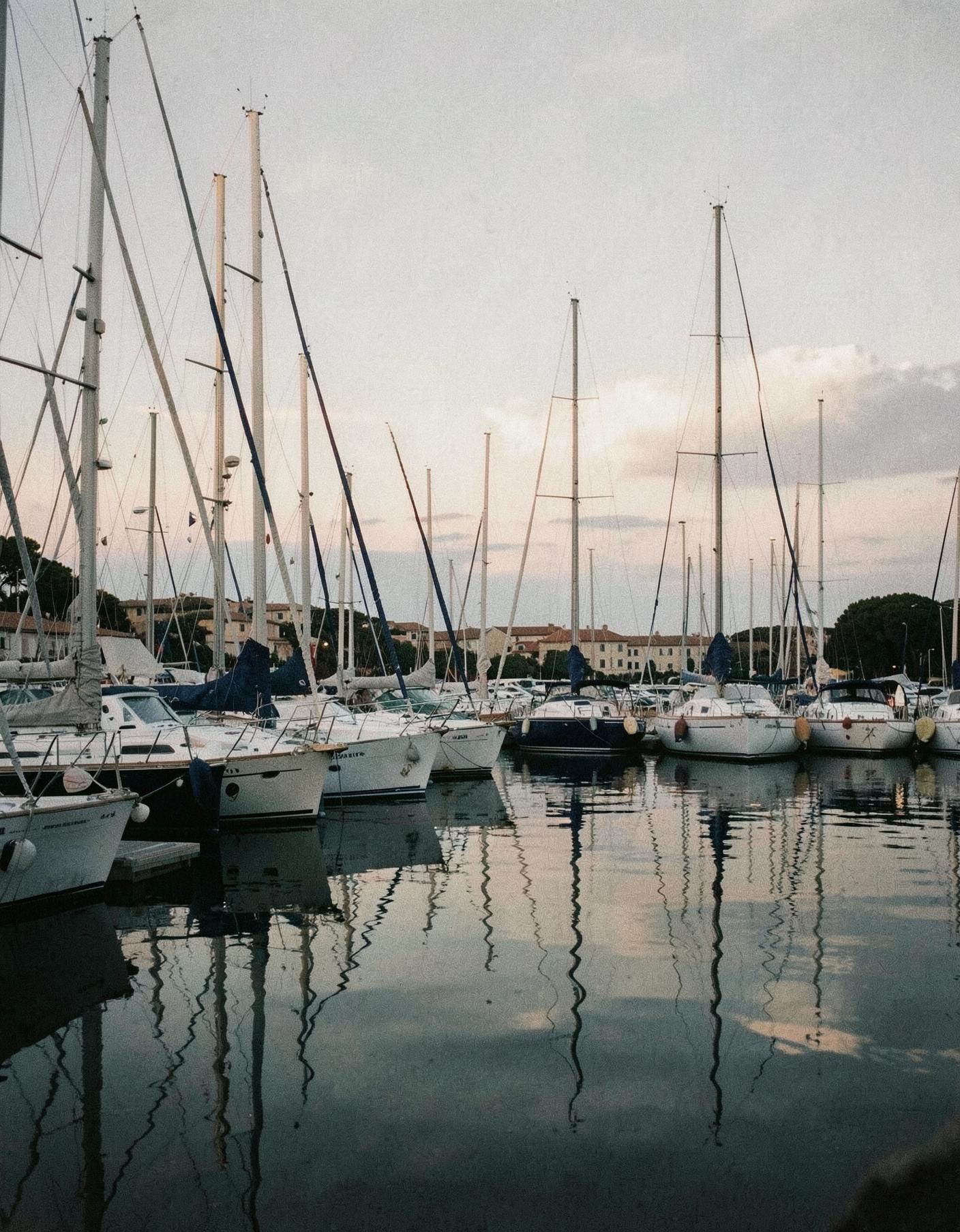 Sailing yachts moored at a quiet Mediterranean marina at dusk